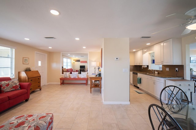 kitchen featuring dishwasher, sink, ceiling fan, tasteful backsplash, and white cabinetry