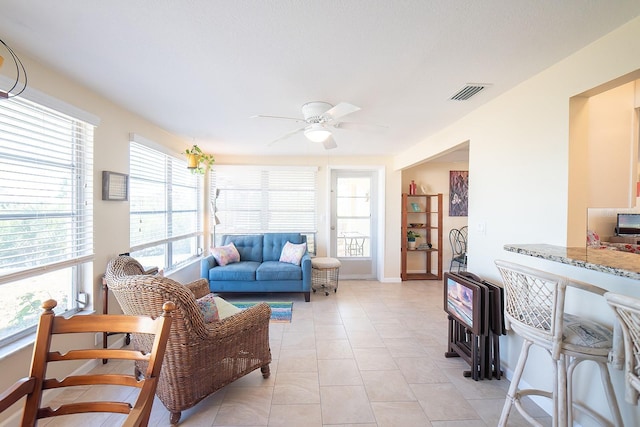 tiled living room with ceiling fan