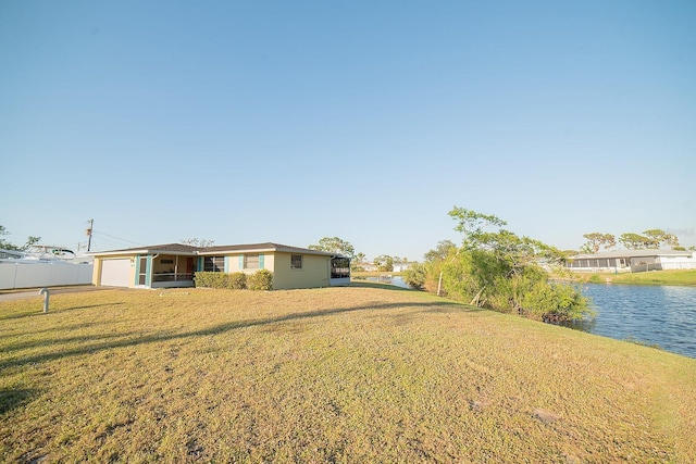 view of yard featuring a garage and a water view