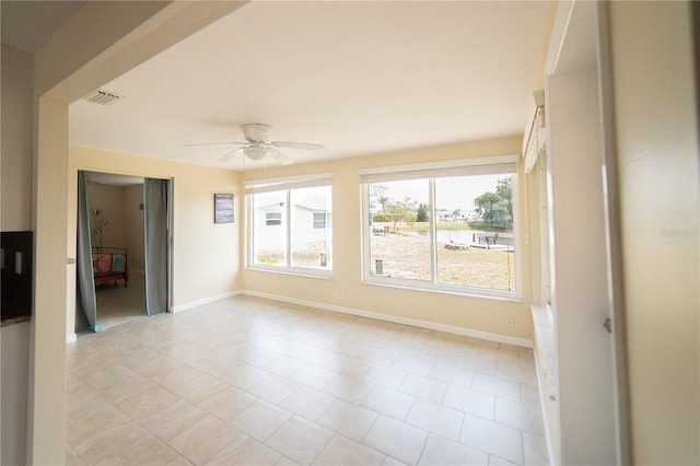 42 Caroll Cir, Englewood, FL 34223 - empty room with ceiling fan, plenty of natural light, and light tile patterned floors