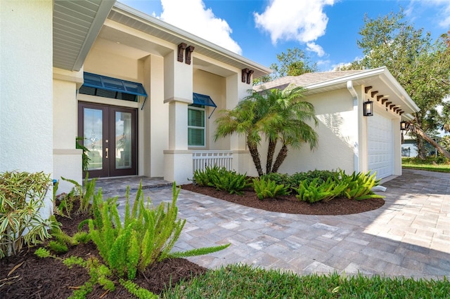 view of exterior entry with french doors and a garage