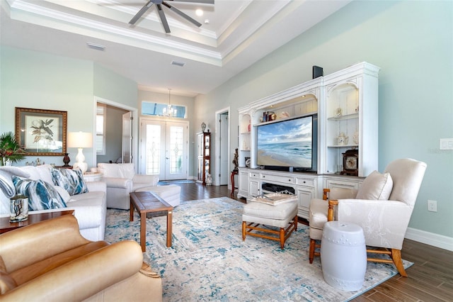 living room with ornamental molding, ceiling fan, a raised ceiling, and dark hardwood / wood-style flooring