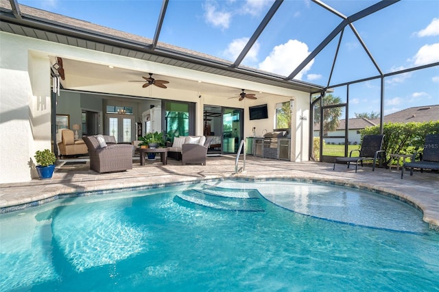 view of pool with an outdoor living space, an outdoor kitchen, a patio, a lanai, and ceiling fan