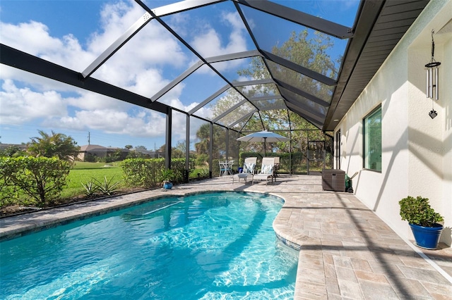 view of swimming pool featuring glass enclosure and a patio area