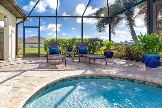 view of swimming pool featuring glass enclosure and a patio area