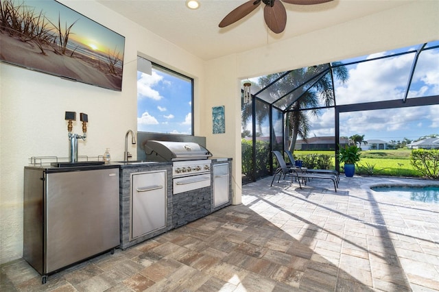 view of patio / terrace featuring sink, an outdoor kitchen, glass enclosure, ceiling fan, and a grill