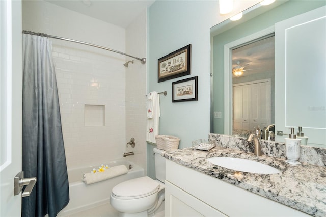 full bathroom featuring vanity, shower / bath combination with curtain, ceiling fan, and toilet