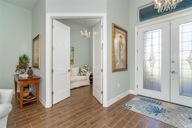 entryway featuring french doors, dark hardwood / wood-style flooring, and an inviting chandelier