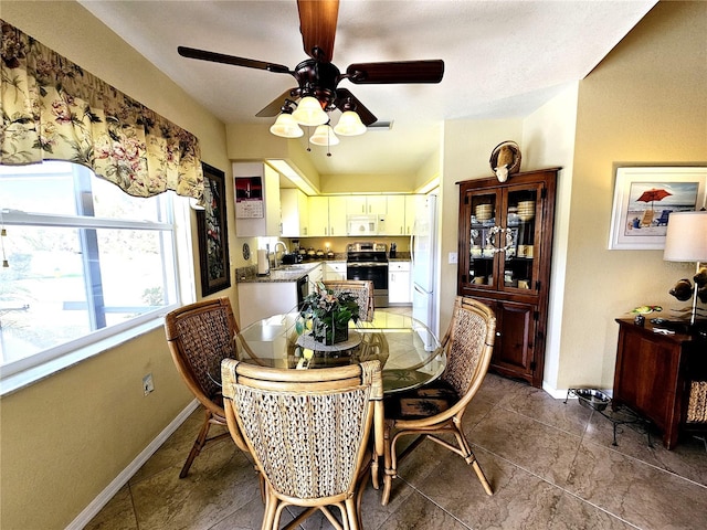 dining area with ceiling fan and sink