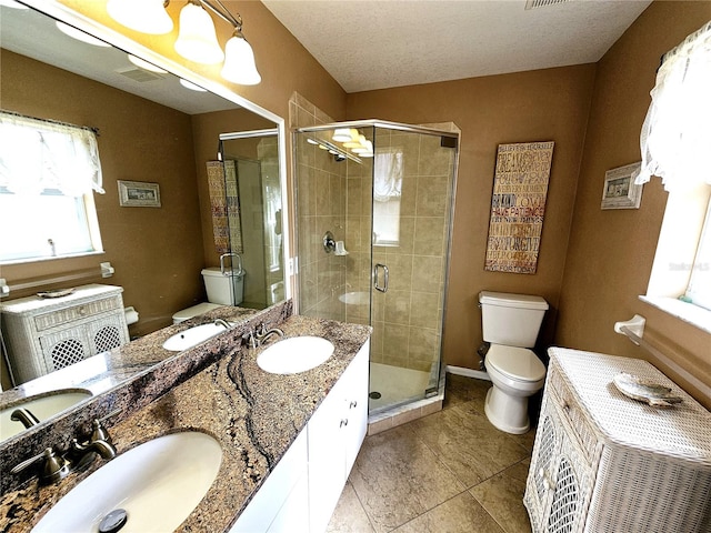 bathroom with tile patterned flooring, vanity, toilet, and walk in shower