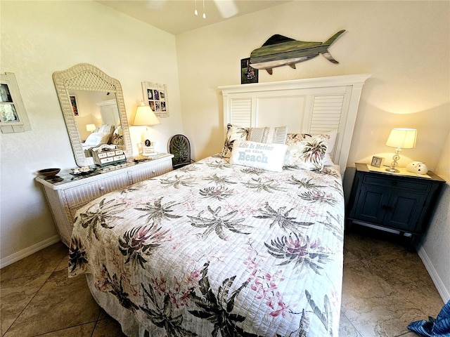 bedroom with ceiling fan and dark tile patterned floors