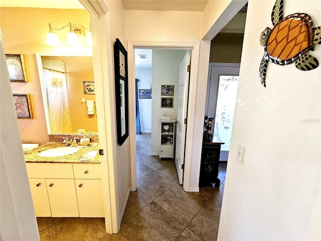 hall featuring sink and dark tile patterned floors