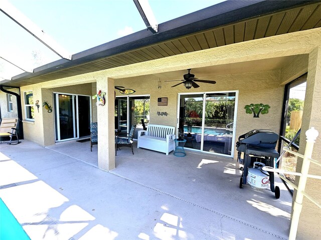 view of patio with a lanai, grilling area, and ceiling fan