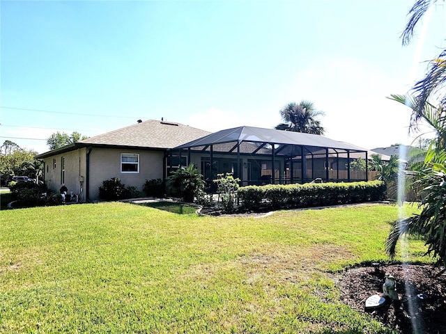 rear view of house featuring a lanai and a yard