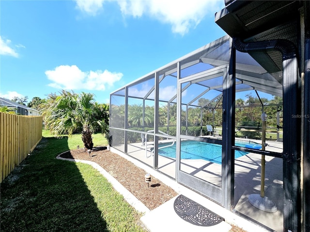 view of swimming pool with glass enclosure, a patio area, and a yard