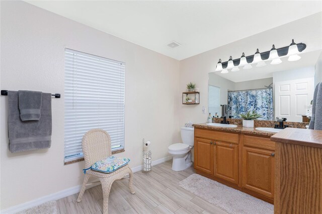 13515 Keystone Blvd, Port Charlotte, FL 33981 - full bath with toilet, double vanity, baseboards, wood finished floors, and a shower with shower curtain