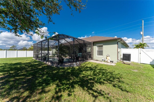 13515 Keystone Blvd, Port Charlotte, FL 33981 - rear view of property with stucco siding, a gate, a patio, and glass enclosure
