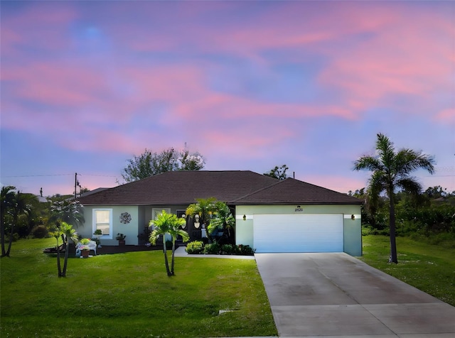 ranch-style house featuring a lawn and a garage