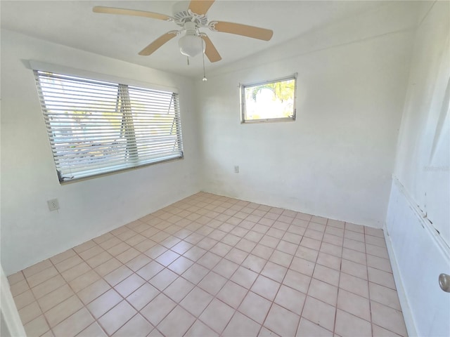 tiled spare room featuring ceiling fan