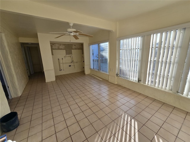 unfurnished sunroom with ceiling fan