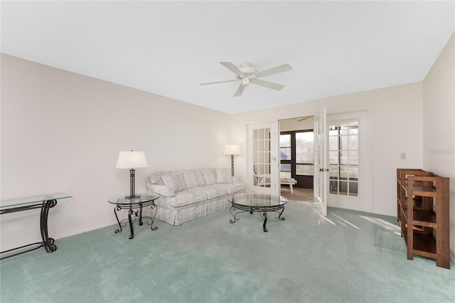 carpeted living room featuring french doors and ceiling fan