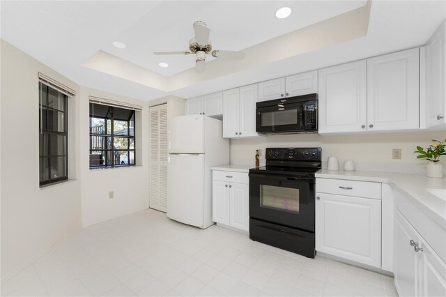 kitchen featuring a raised ceiling, ceiling fan, white cabinets, and black appliances