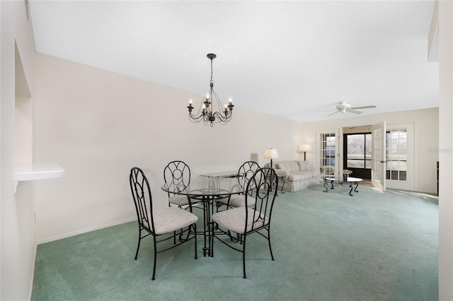 carpeted dining space featuring ceiling fan with notable chandelier