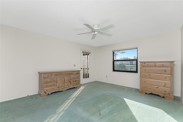 unfurnished bedroom featuring carpet, a textured ceiling, and ceiling fan