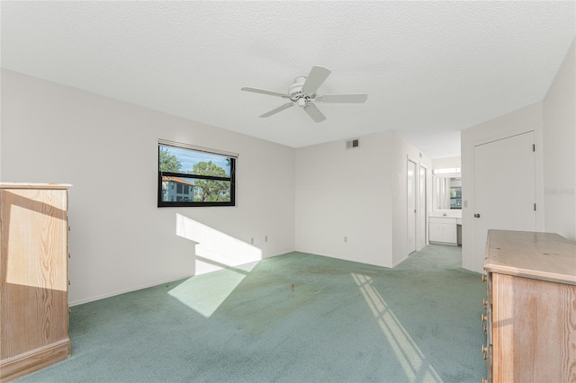 unfurnished living room featuring carpet flooring, a textured ceiling, and ceiling fan