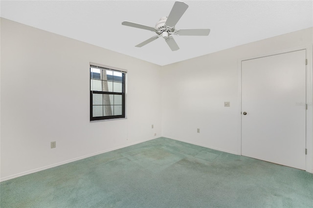 carpeted empty room featuring ceiling fan