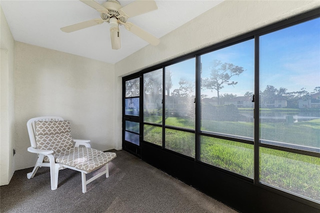 sunroom / solarium with a water view and ceiling fan