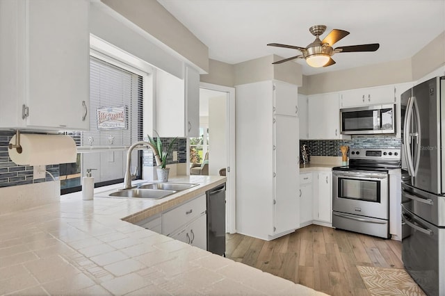 kitchen featuring white cabinetry, sink, appliances with stainless steel finishes, and light hardwood / wood-style flooring