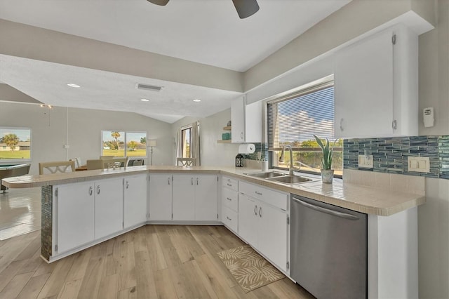 kitchen featuring dishwasher, kitchen peninsula, white cabinetry, and sink