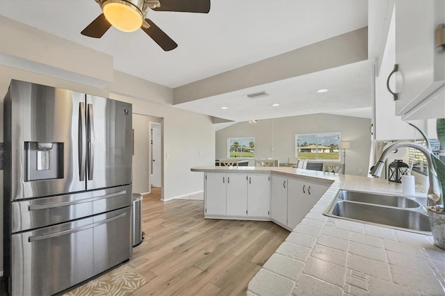 kitchen with lofted ceiling, sink, stainless steel refrigerator with ice dispenser, light hardwood / wood-style floors, and white cabinetry