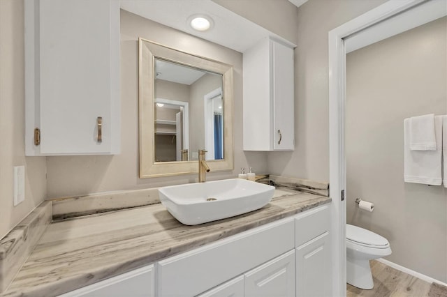 bathroom featuring hardwood / wood-style floors, vanity, and toilet