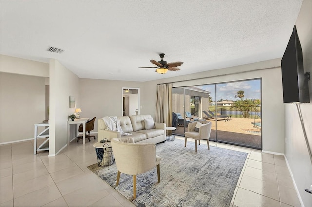 tiled living room with ceiling fan and a textured ceiling