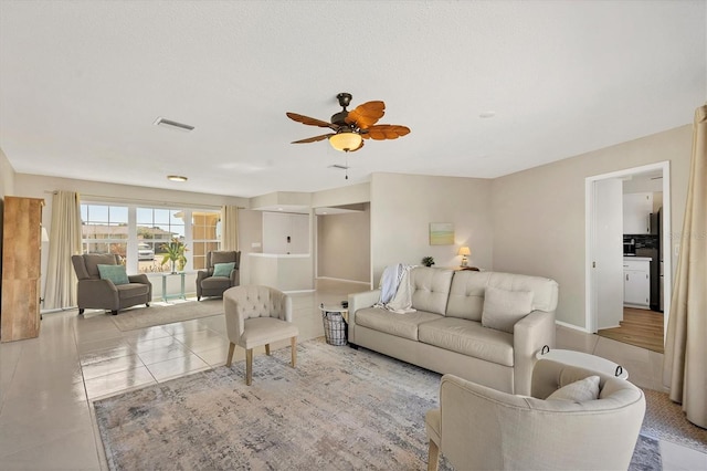 living room featuring light tile patterned floors and ceiling fan