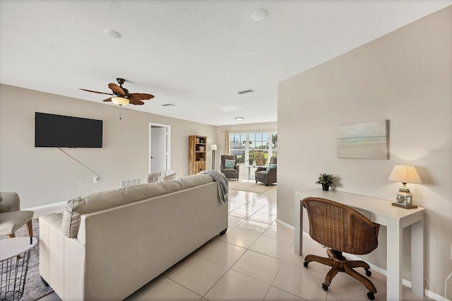 tiled living room featuring ceiling fan and a textured ceiling