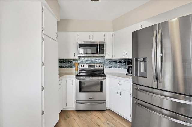 kitchen featuring decorative backsplash, stainless steel appliances, white cabinetry, and light hardwood / wood-style floors