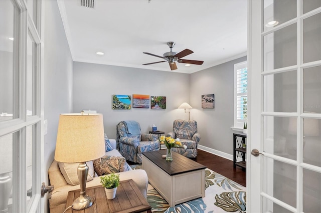 living room featuring french doors, ornamental molding, ceiling fan, and dark wood-type flooring