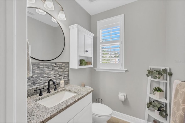 bathroom with decorative backsplash, vanity, and toilet