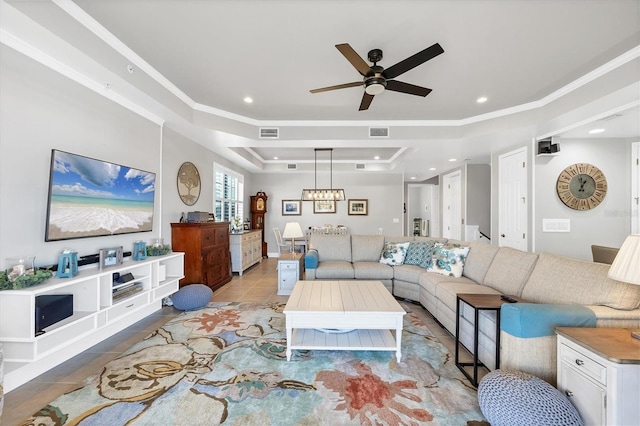 living room with a raised ceiling, ceiling fan, crown molding, and light tile patterned flooring