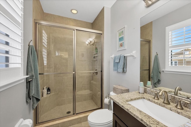 bathroom featuring tile patterned flooring, vanity, toilet, and walk in shower