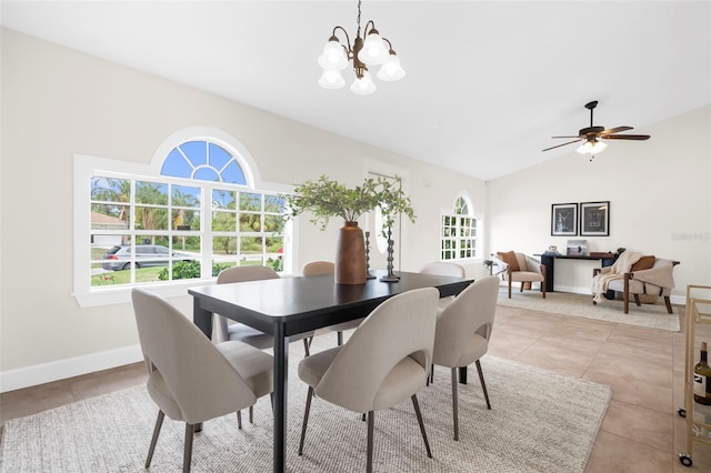 tiled dining space with ceiling fan with notable chandelier and vaulted ceiling