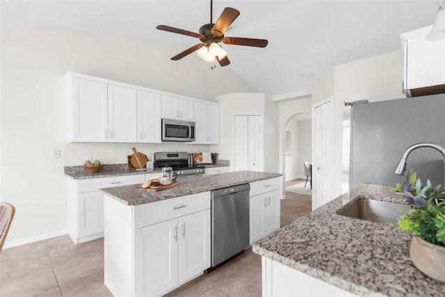 kitchen with sink, white cabinets, stainless steel appliances, and vaulted ceiling