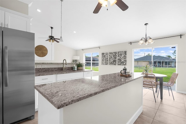 kitchen with white cabinets, plenty of natural light, and stainless steel fridge