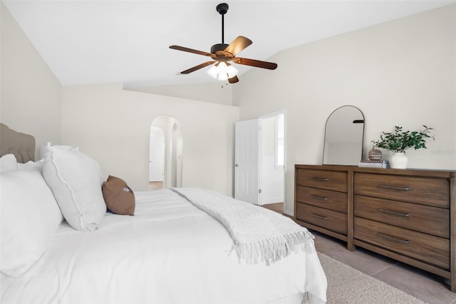 bedroom featuring ceiling fan, light tile patterned floors, and vaulted ceiling