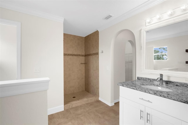 bathroom featuring tile patterned floors, vanity, ornamental molding, and tiled shower