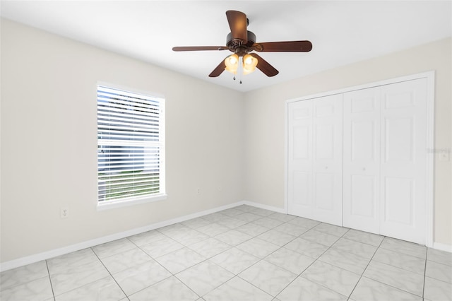 unfurnished bedroom featuring ceiling fan, a closet, and light tile patterned flooring