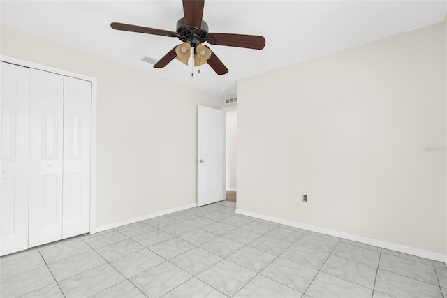 unfurnished bedroom with ceiling fan, a closet, and light tile patterned floors